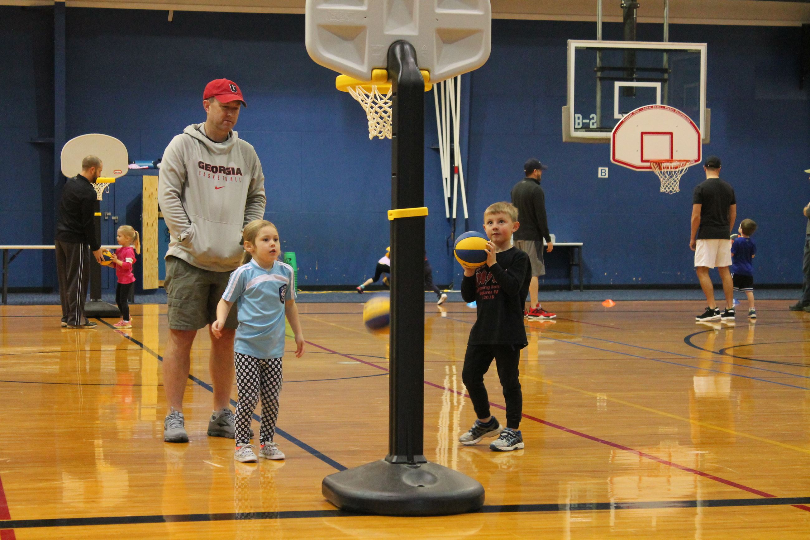 young children shooting basketball into goal