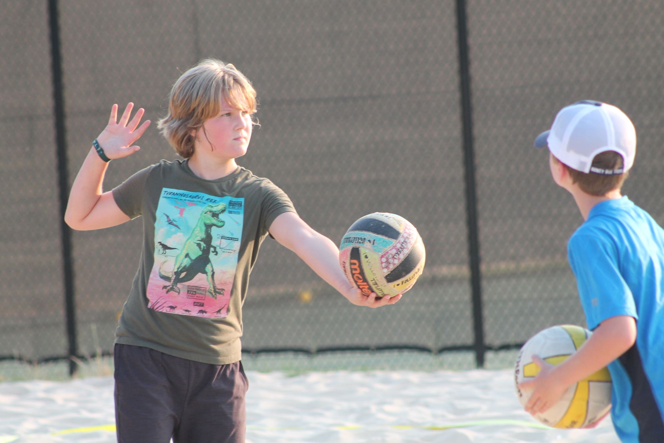 Serving volleyball on sand court