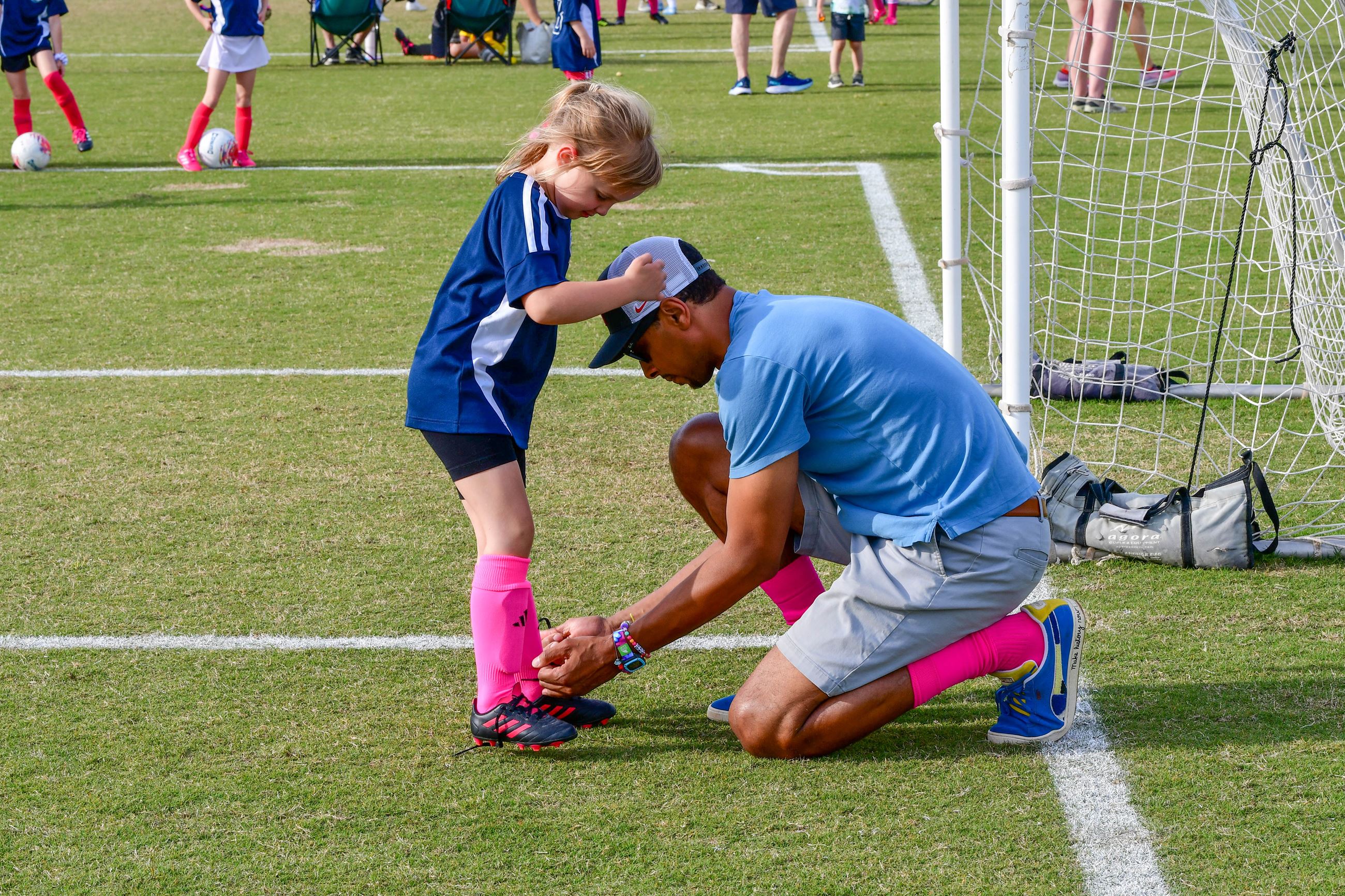 Coach kneeling down to tie a player's shoe