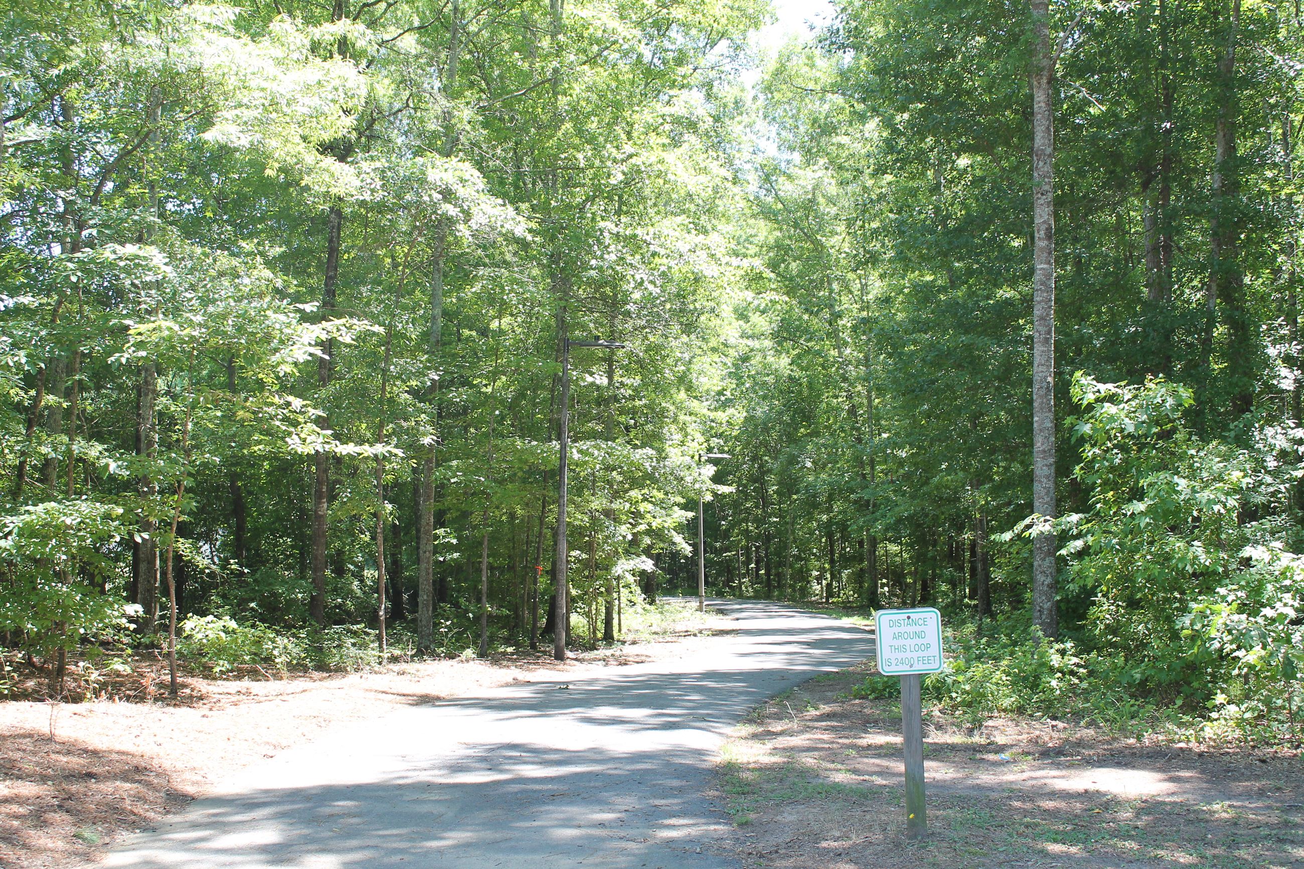 paved walking trail surrounded by woods at Bogart Sports Complex